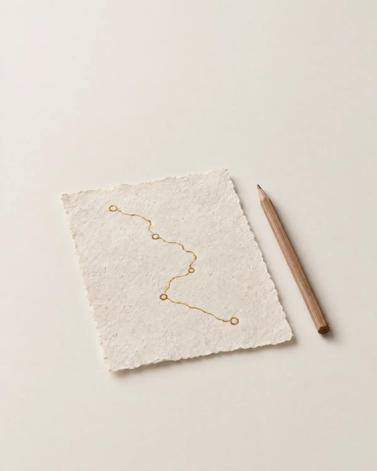 A route drawn in ochre ink on a sheet of washi paper, a pencil beside it.